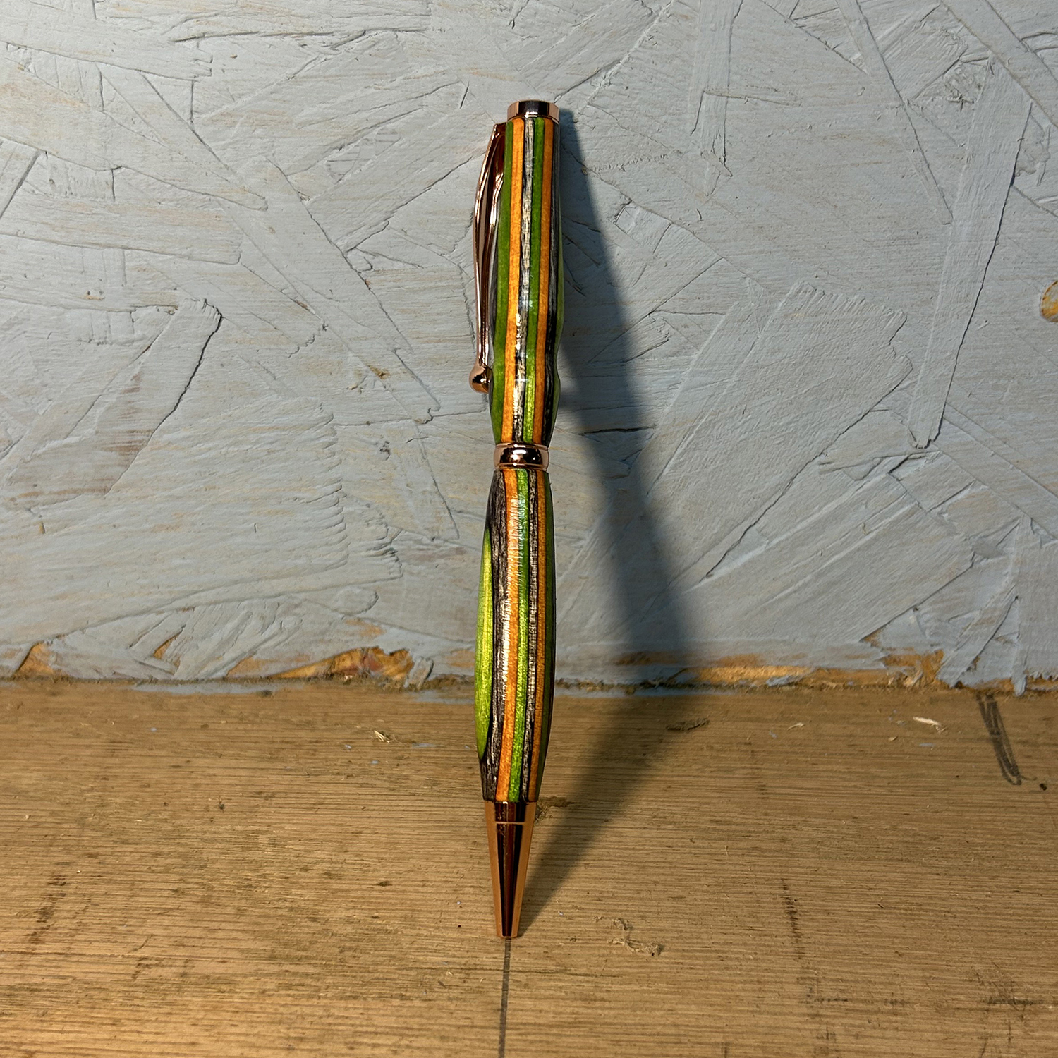 Custom handmade pen with lines of golden orange, green and natural colors.